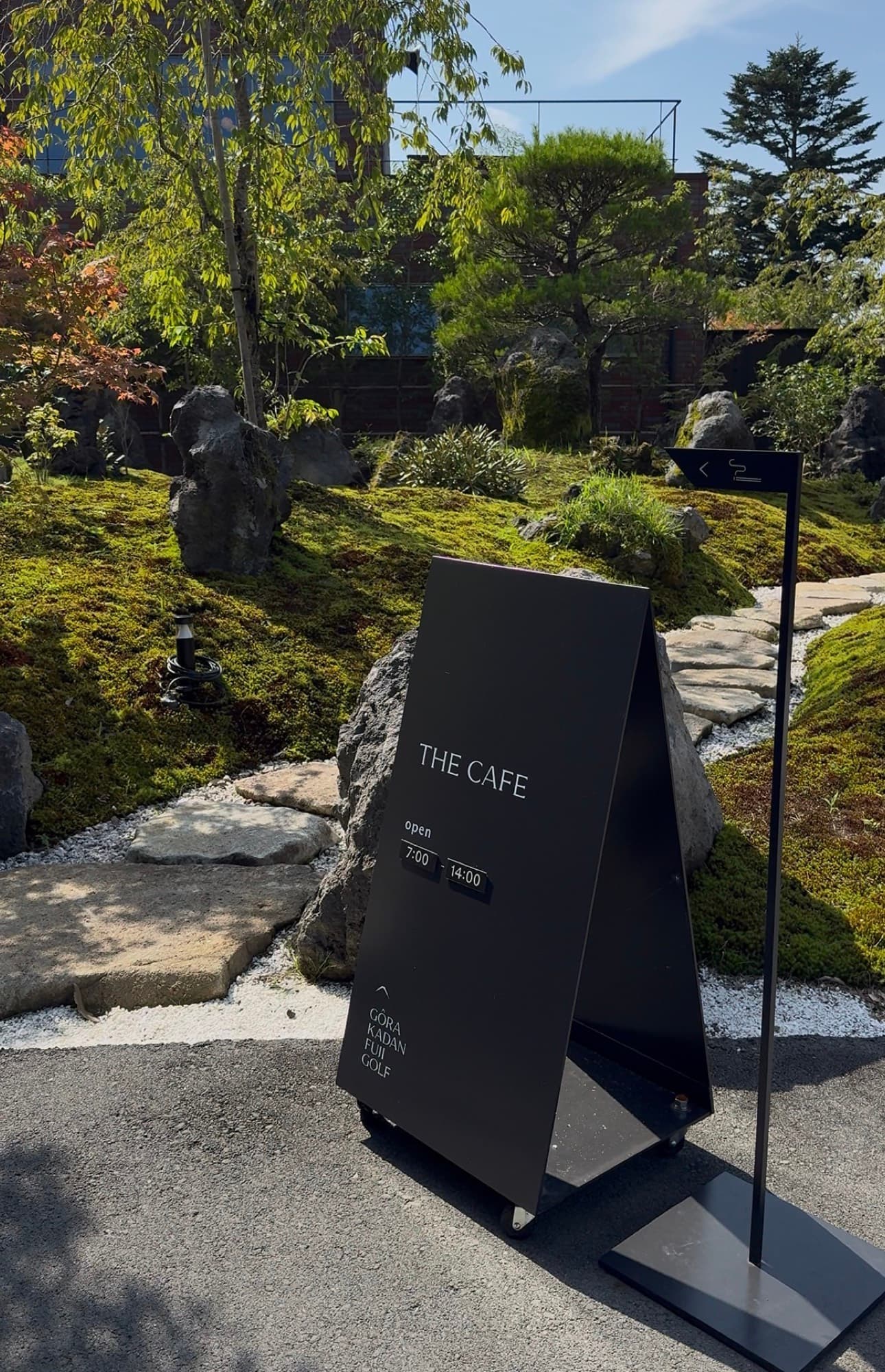 The THE CAFE sign on the garden path