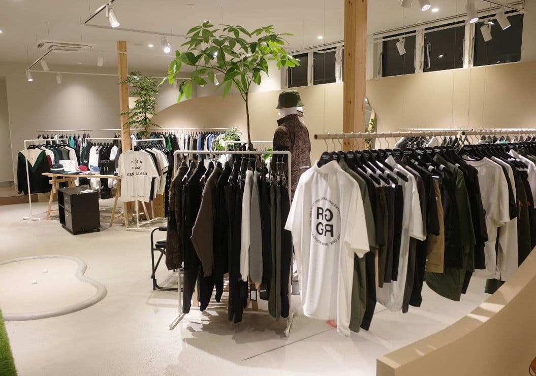 Inside RUFFLOG Kanazawa — golf apparel on racks with an indoor putting mat